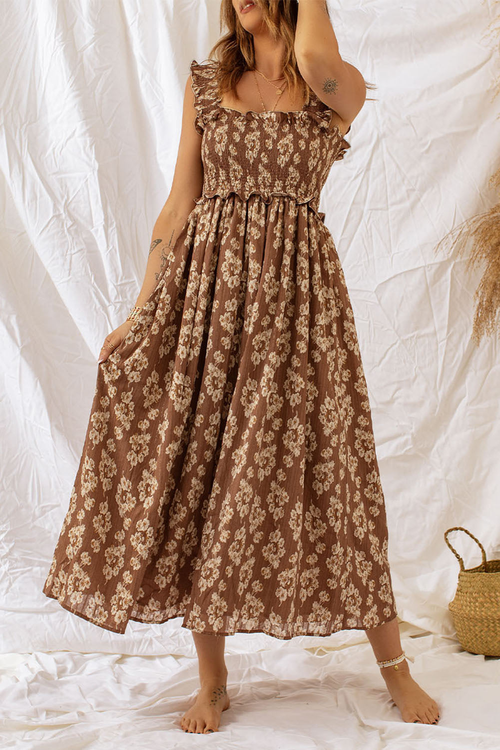 Brown ruffled straps smocked floral maxi dress on model with white background.