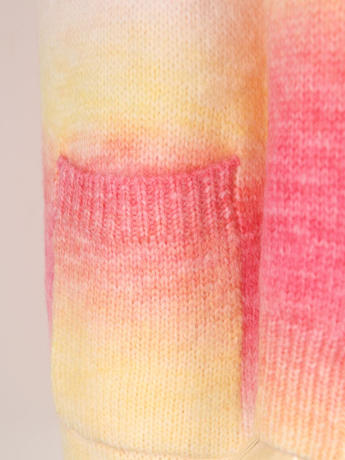 Close-up of Rainbow Pocketed Open Front Gradient Cardigan showing pink and yellow gradient knit fabric with pocket detail.