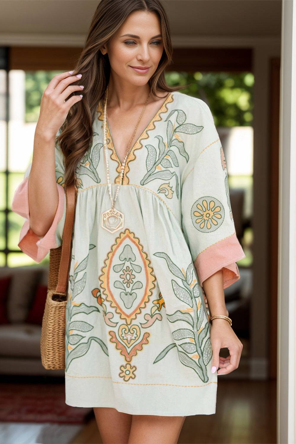 Printed V-neck three-quarter sleeve mini dress in 100% polyester with decorative patterns.