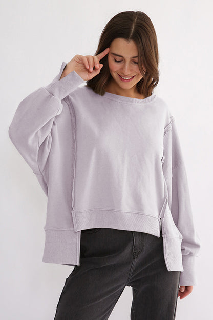 Exposed seam high-low long sleeve sweatshirt with slit, slightly stretchy, 100% cotton.