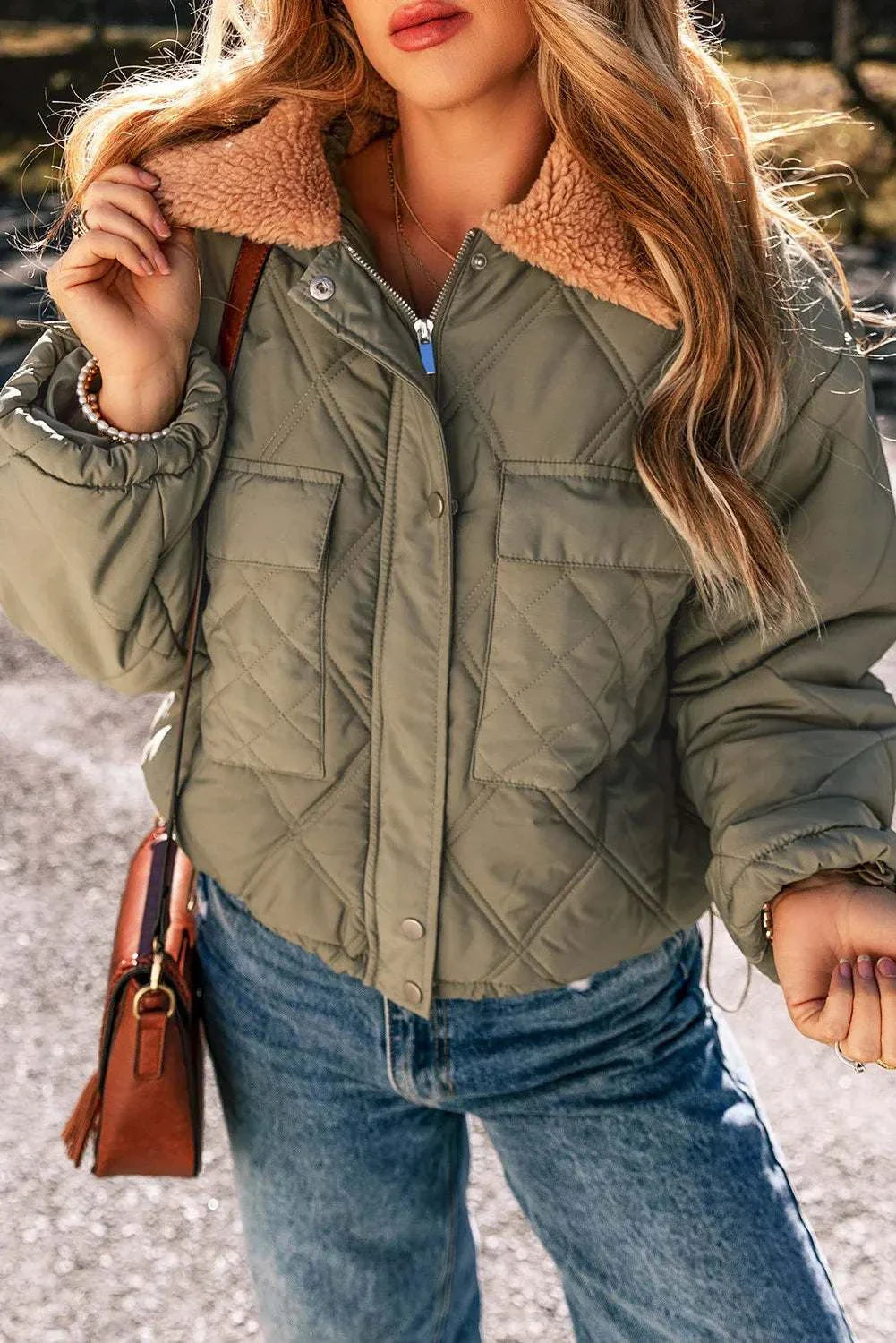 Sherpa collared neck long sleeve winter coat with pockets, worn by a woman outdoors.