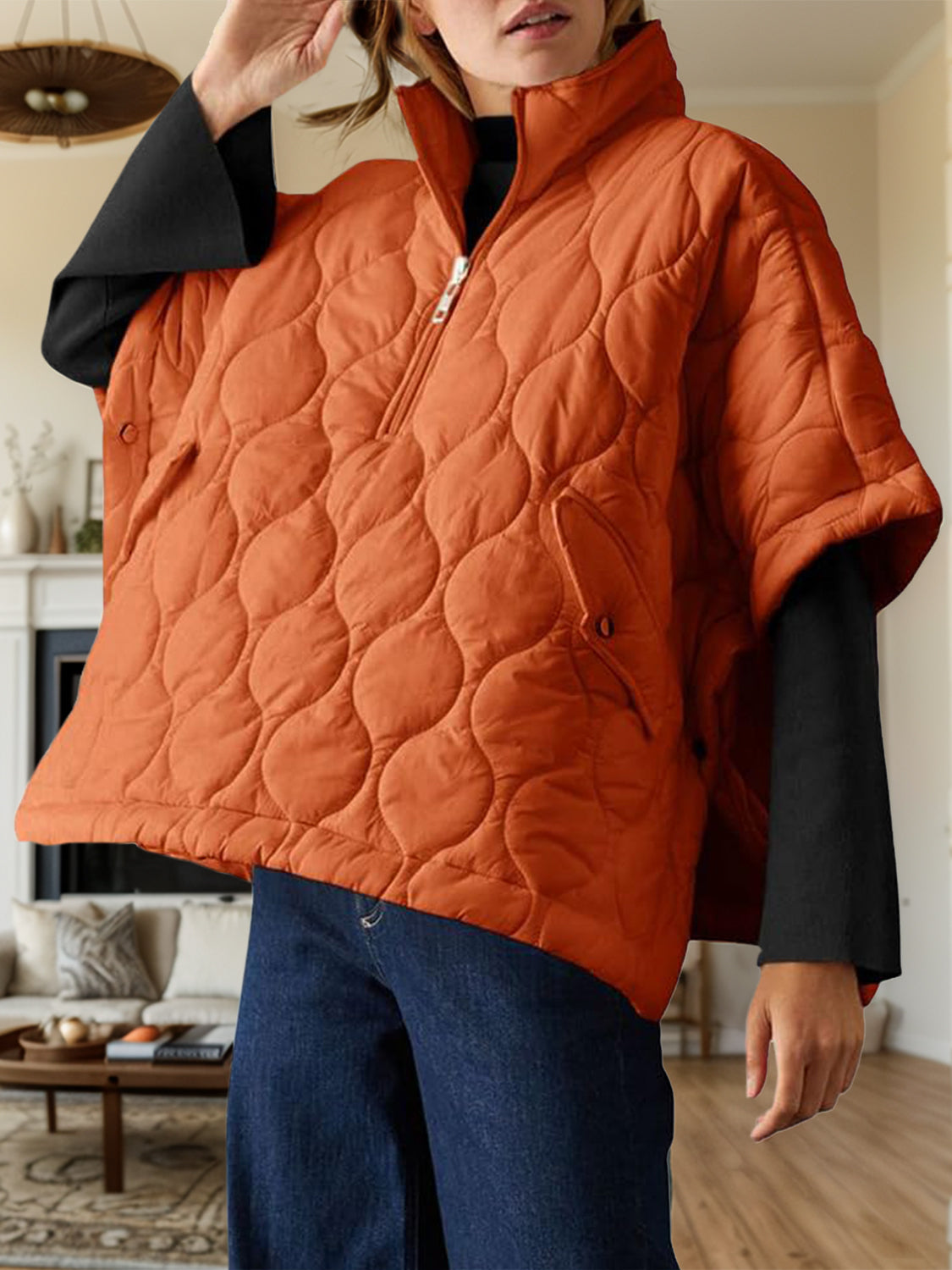 Textured half zip pullover poncho in orange with lined body and quilted design.