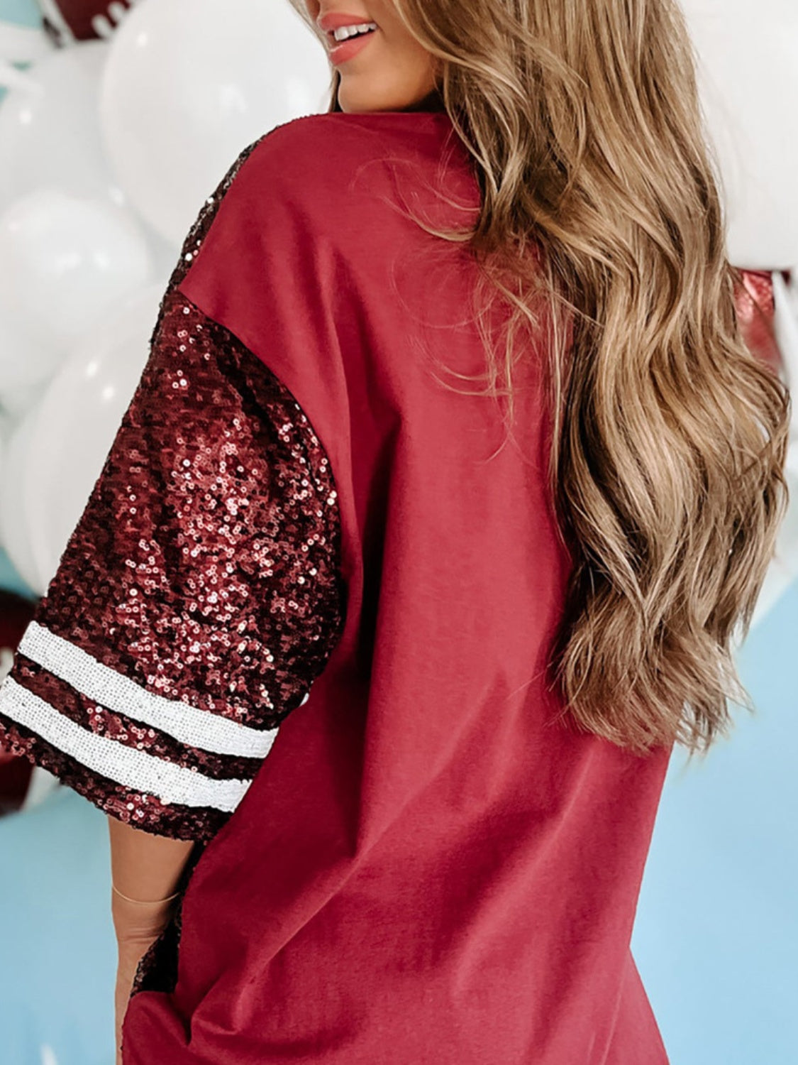 Red sequin football oversized T-shirt with striped sleeves.