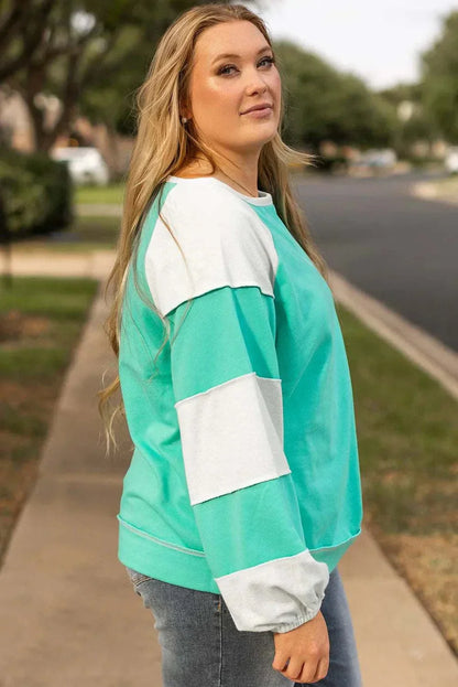 Plus size color block long sleeve sweatshirt with exposed seam.