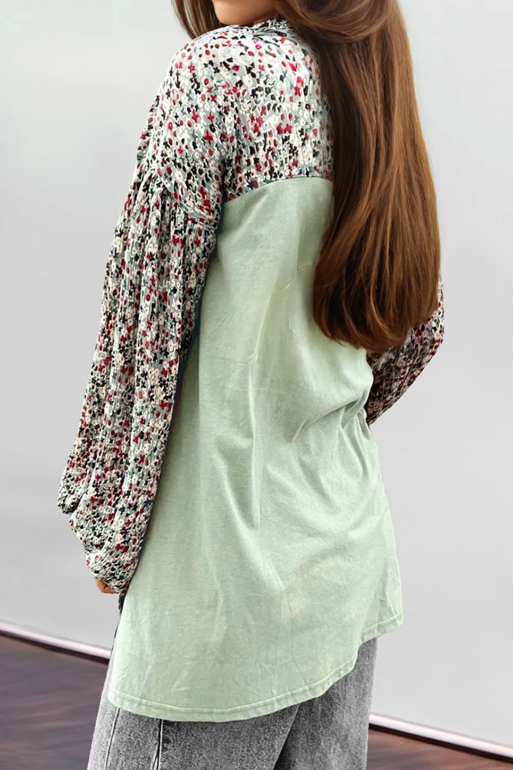 Printed notched long sleeve blouse with buttoned details, featuring a floral pattern and slightly stretchy fabric.