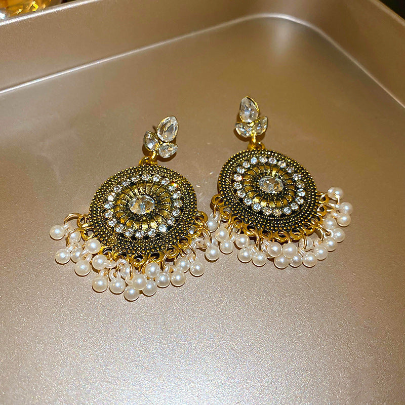 Rhinestone alloy bead dangle earrings with intricate design on gold tray.