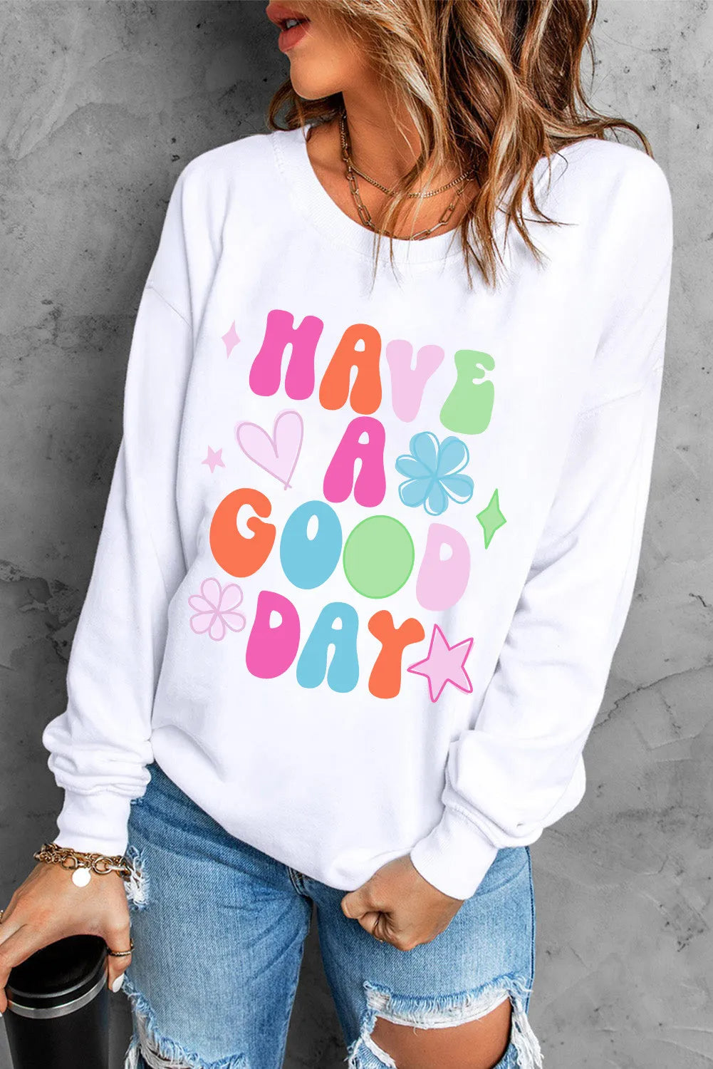 Have A Good Day Graphic Sweatshirt with colorful text design, worn by woman with denim shorts.