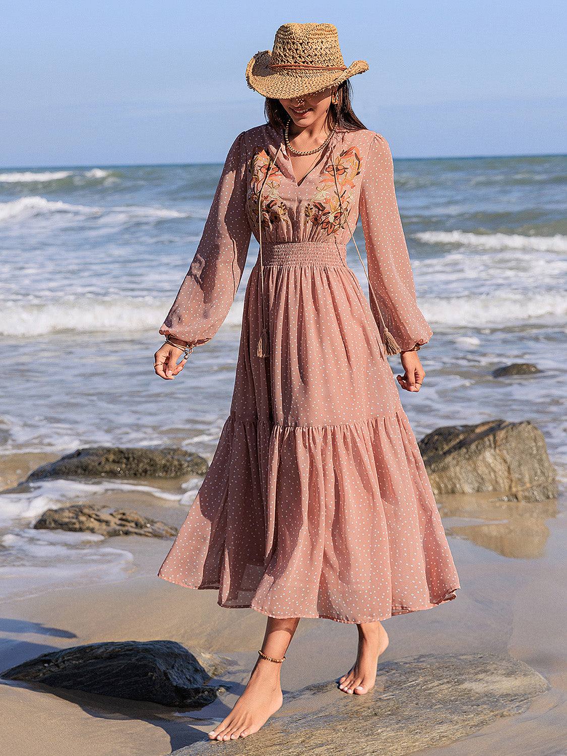 Embroidered polka dot tie neck long sleeve midi dress on woman at beach.