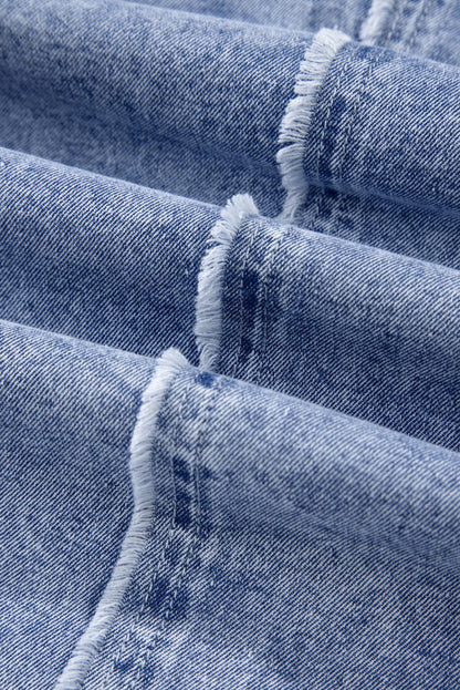 Close-up of raw hem detail on a long sleeve denim dress.