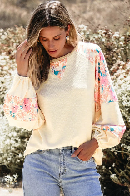 Printed round neck balloon sleeve blouse with floral design.