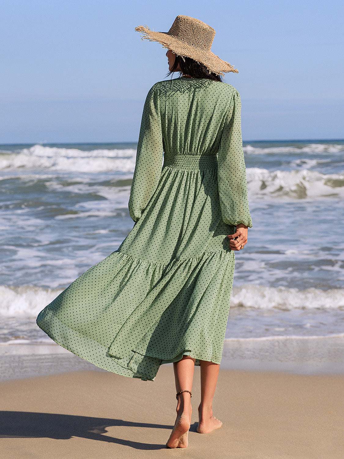 Embroidered polka dot tie neck long sleeve midi dress on beach.