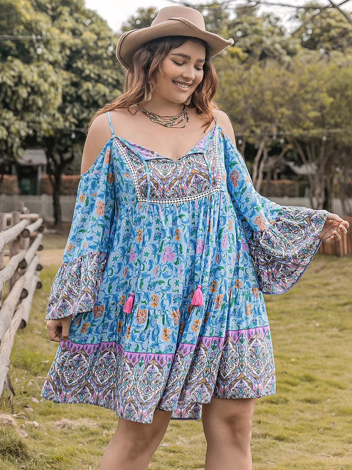 Plus size printed long sleeve mini dress in blue with colorful patterns, featuring a tied design and opaque fabric.