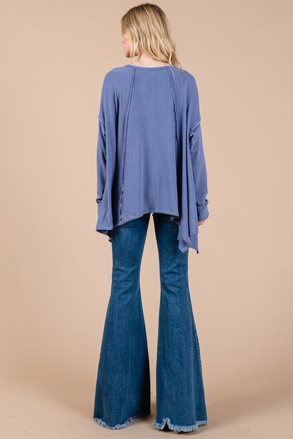 Oversized asymmetrical long sleeve top with drop sleeves and hi-low hem in blue.