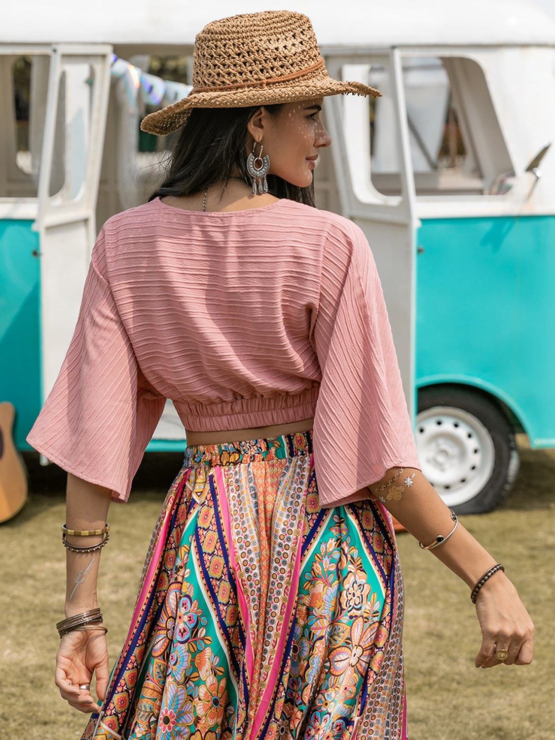 Boho crop top with textured V-neck design and ruched details, paired with a vibrant, patterned skirt.