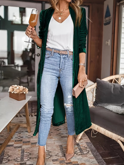 Woman wearing an open front long sleeve coat over casual outfit indoors.