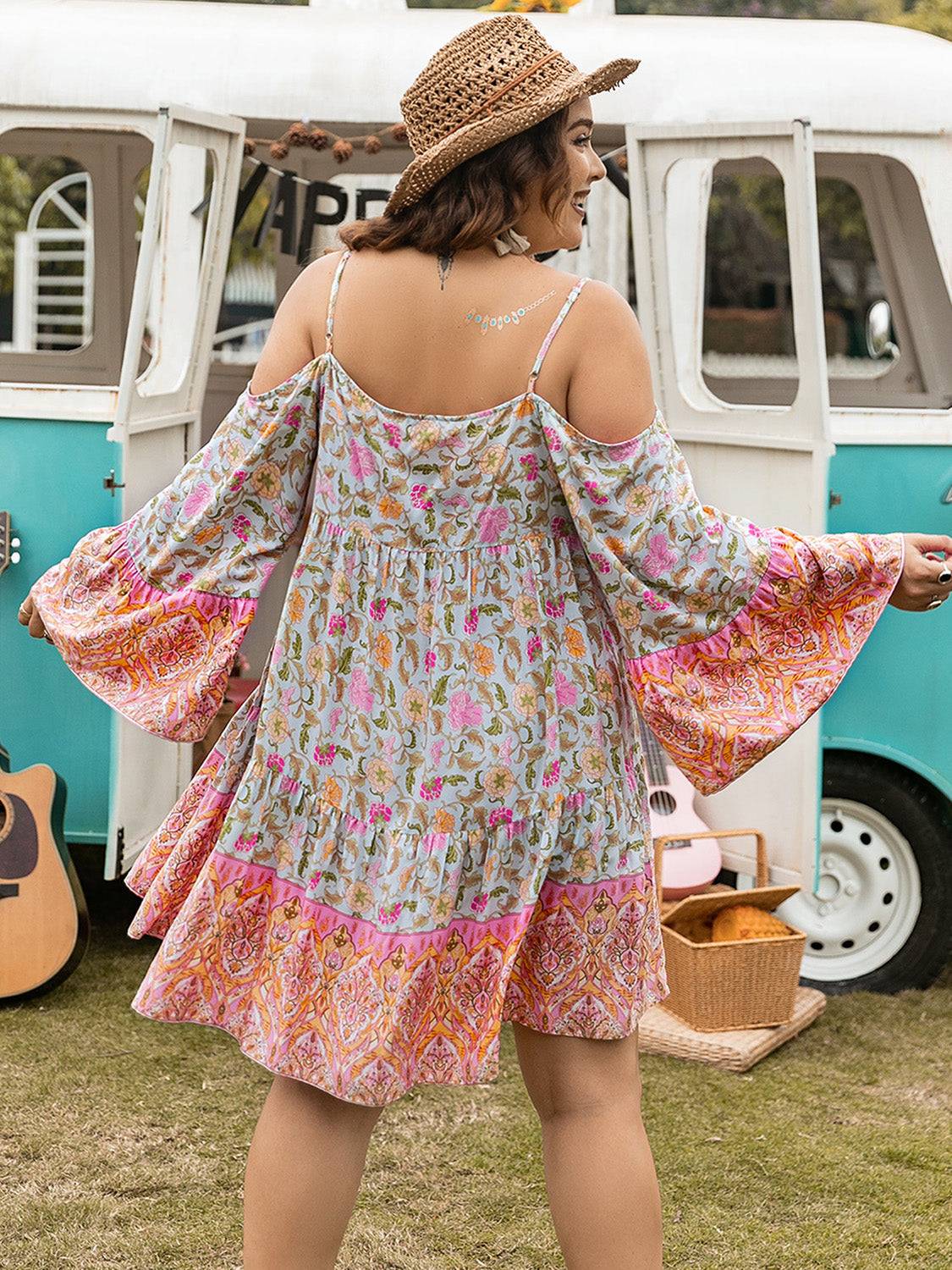 Plus size printed long sleeve mini dress with floral patterns, featuring a tied design and vibrant colors.