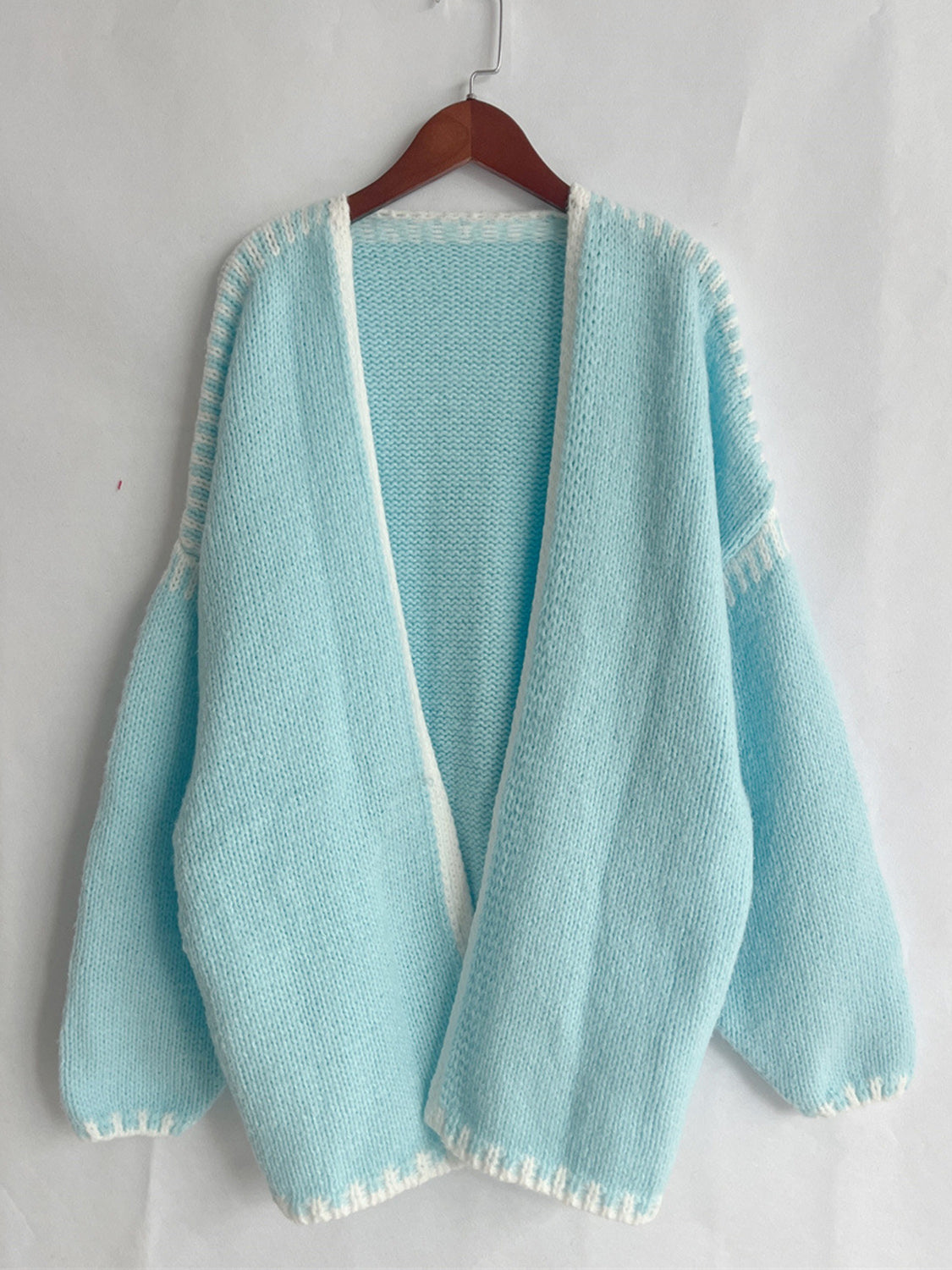 Light blue open cardigan, featuring a basic style with slight stretch, made from 100% polyester.