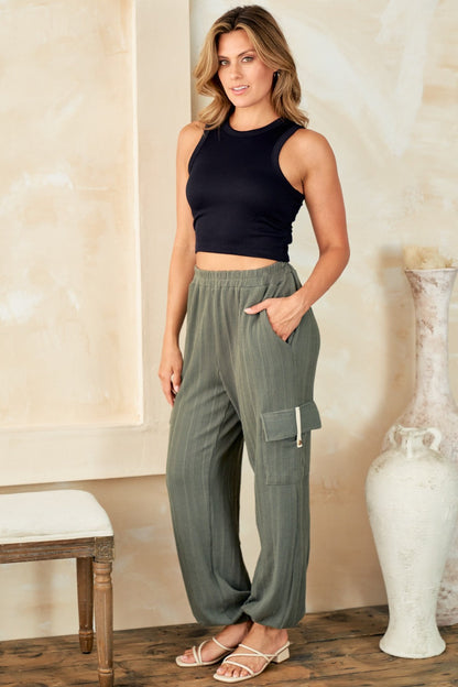 Textured rib cargo pants with contrast twill tape and button detail, pocketed, worn by a woman in a casual setting.