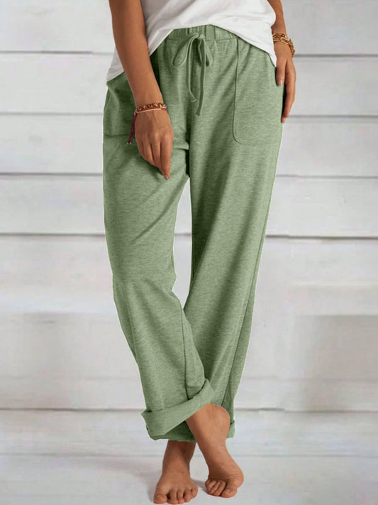 Tied wide leg pants with pockets in green fabric.