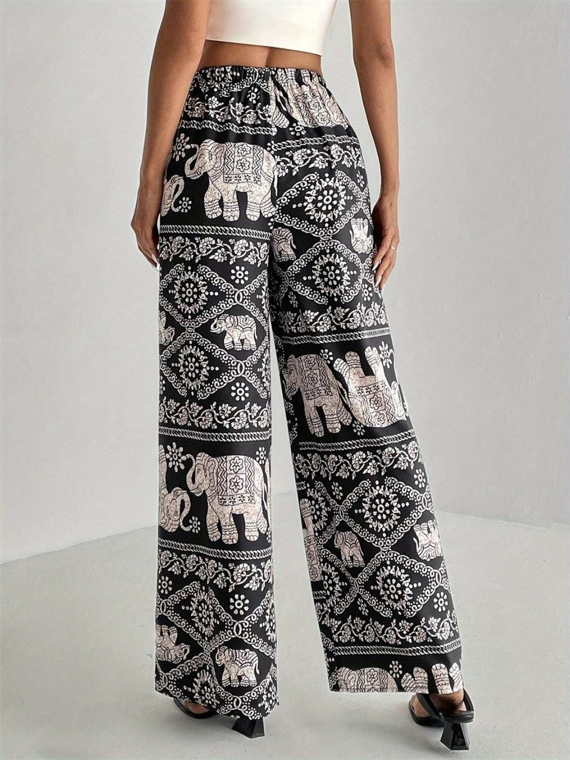 Black and white printed wide leg elastic waist pants featuring an elephant pattern.