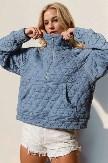 Half zip long sleeve quilted sweatshirt with pocket in blue.