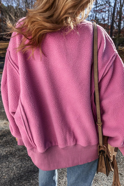 Pink slit round neck long sleeve sweatshirt with exposed seam and high-low design.