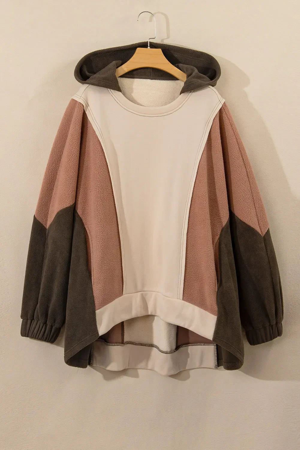 Plus Size Color Block Long Sleeve Hoodie with neutral tones hanging on a hanger.