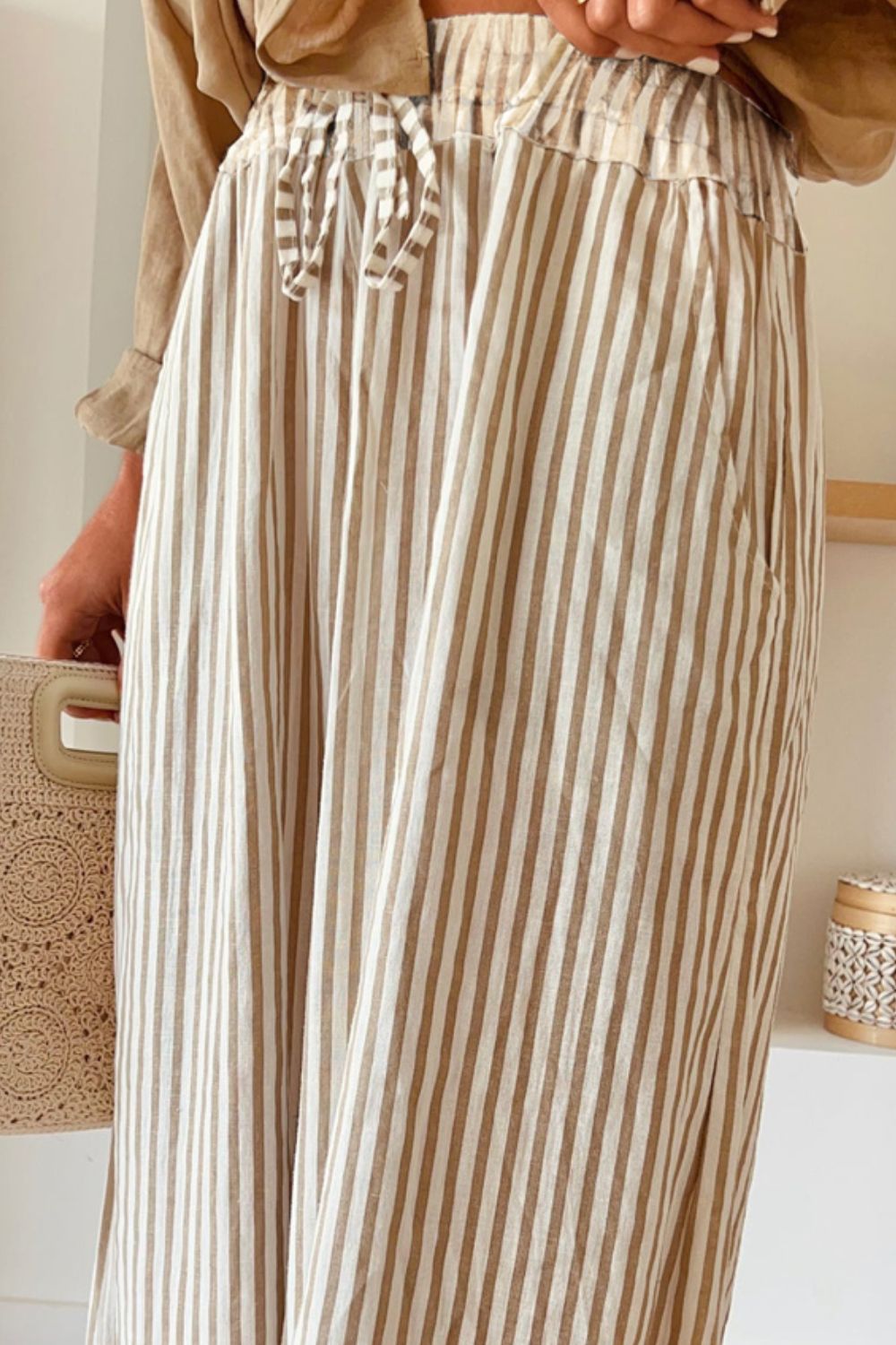 Pocketed striped wide leg pants with high waist and drawstring, ideal for a casual chic look.