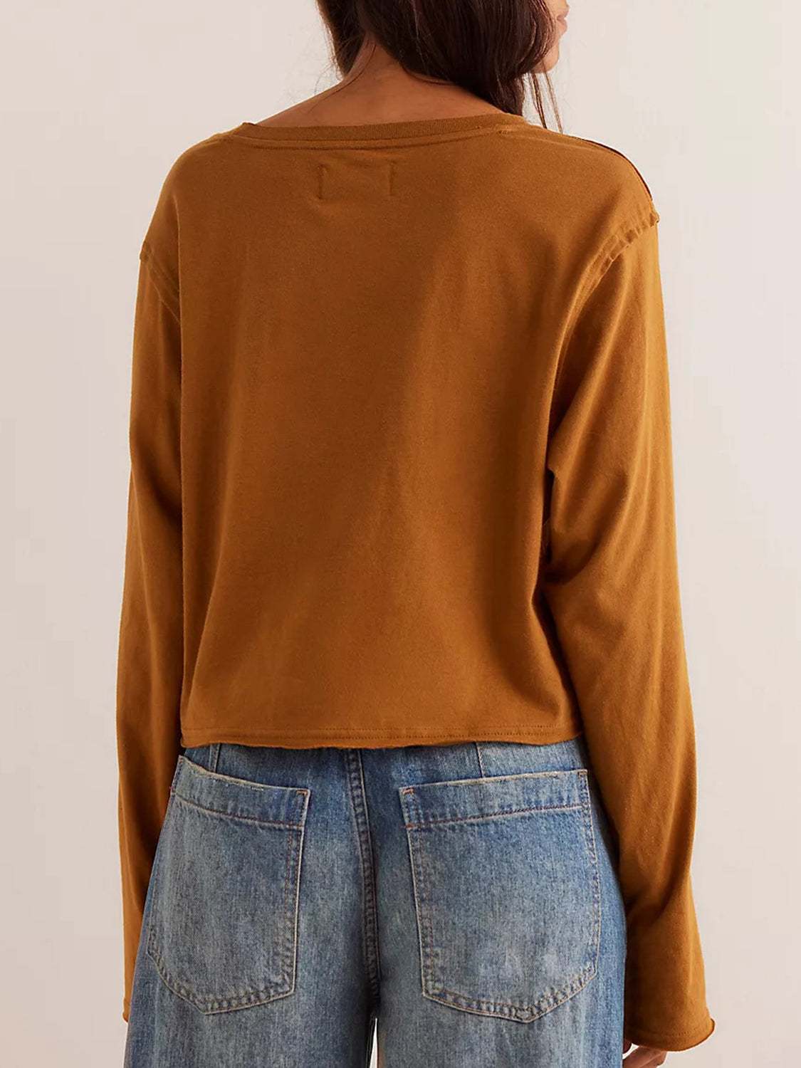 Round Neck Long Sleeve Cropped Tee in brown paired with blue jeans, back view.