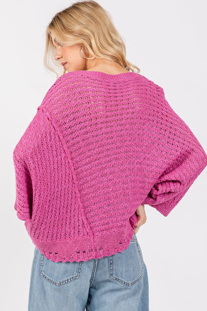 Distressed asymmetrical open stitch sweater in magenta with round neckline and half sleeves.