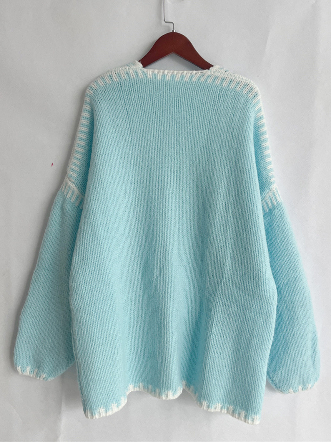 Light blue, slightly stretchy super cozy open cardigan made of 100% polyester, displayed on a hanger.