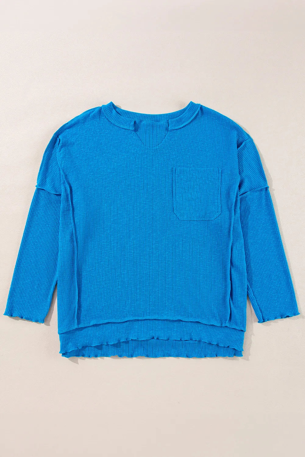 Blue exposed seam notched long sleeve blouse with pocket detail.