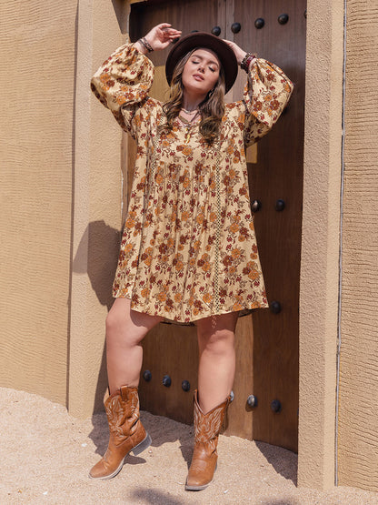 Plus size printed V-neck balloon sleeve mini dress in a floral pattern, worn with cowboy boots and a hat.