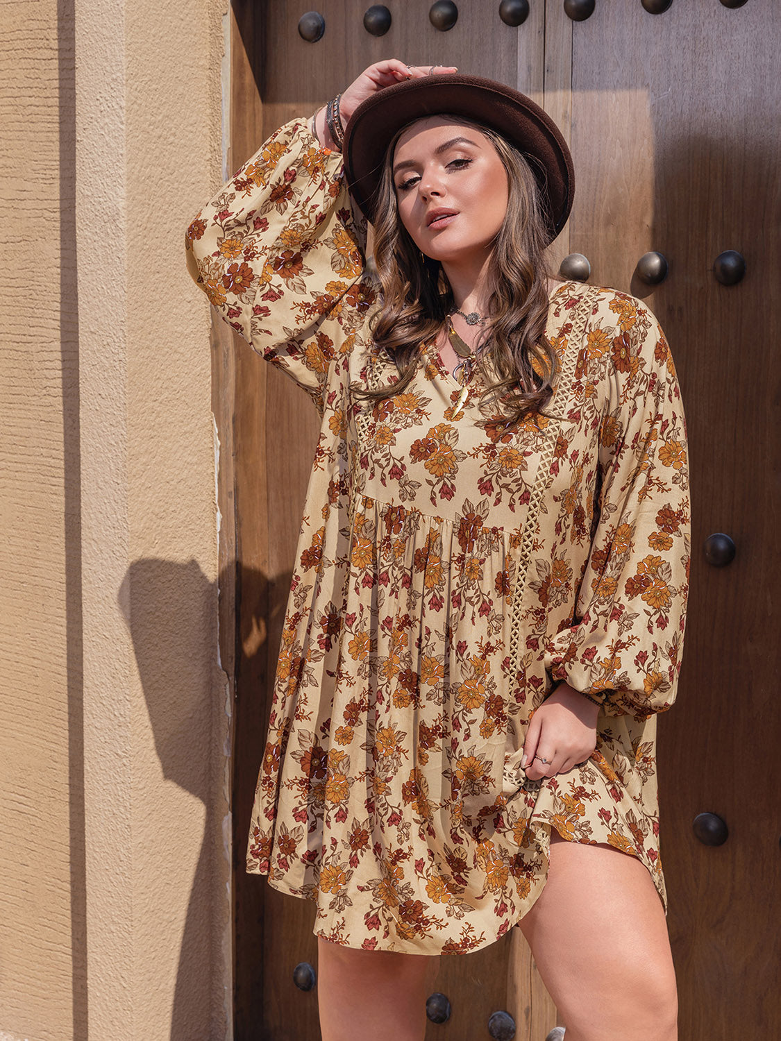 Plus size printed V-neck balloon sleeve mini dress in floral pattern.