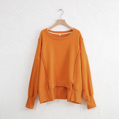 Exposed seam high-low orange sweatshirt with long sleeves, slit design, made of 100% cotton.