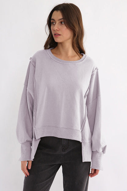 Exposed seam high-low long sleeve sweatshirt in lavender, cotton material.