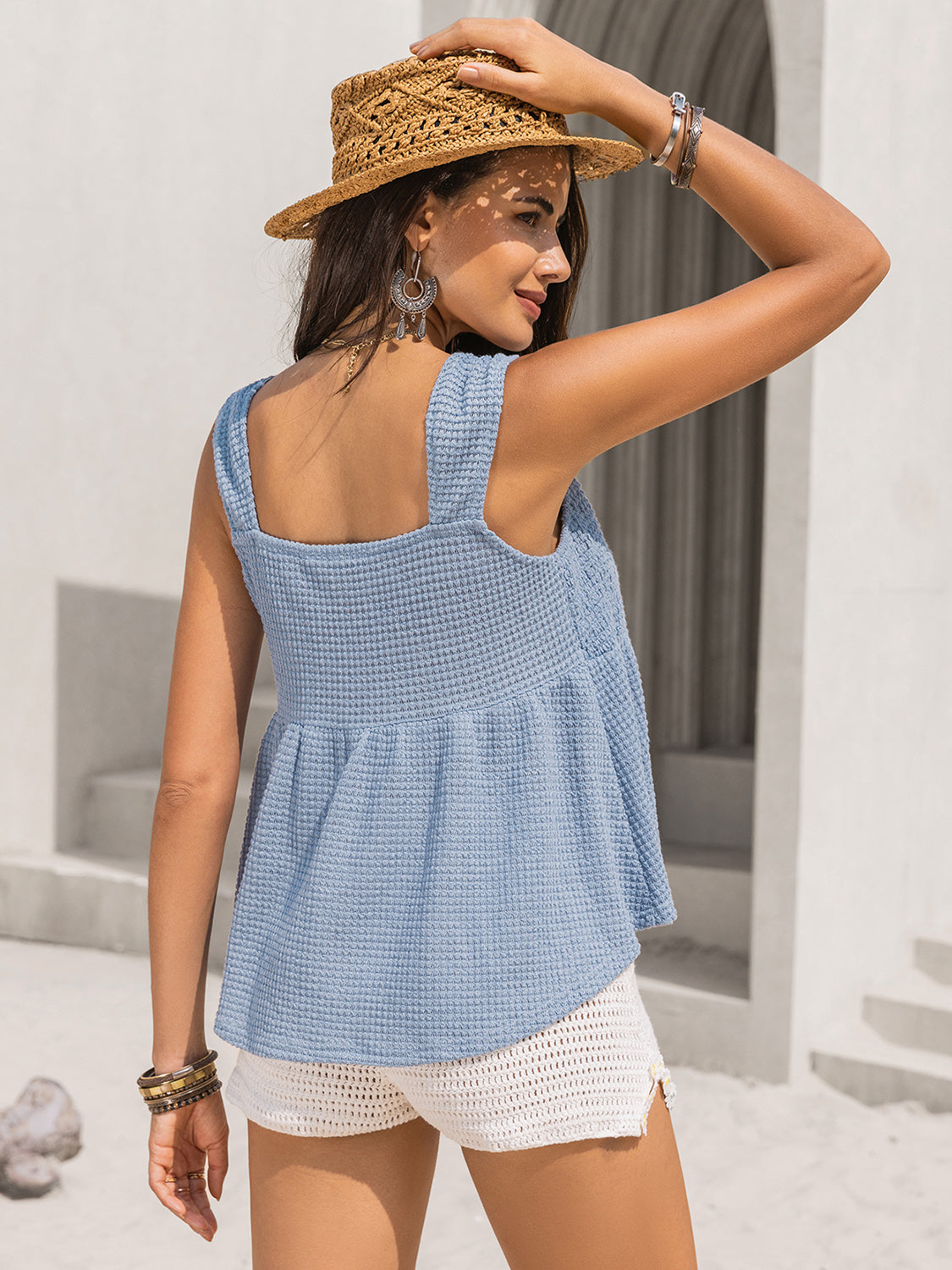 Woman wearing a blue textured tied V-neck tank top.