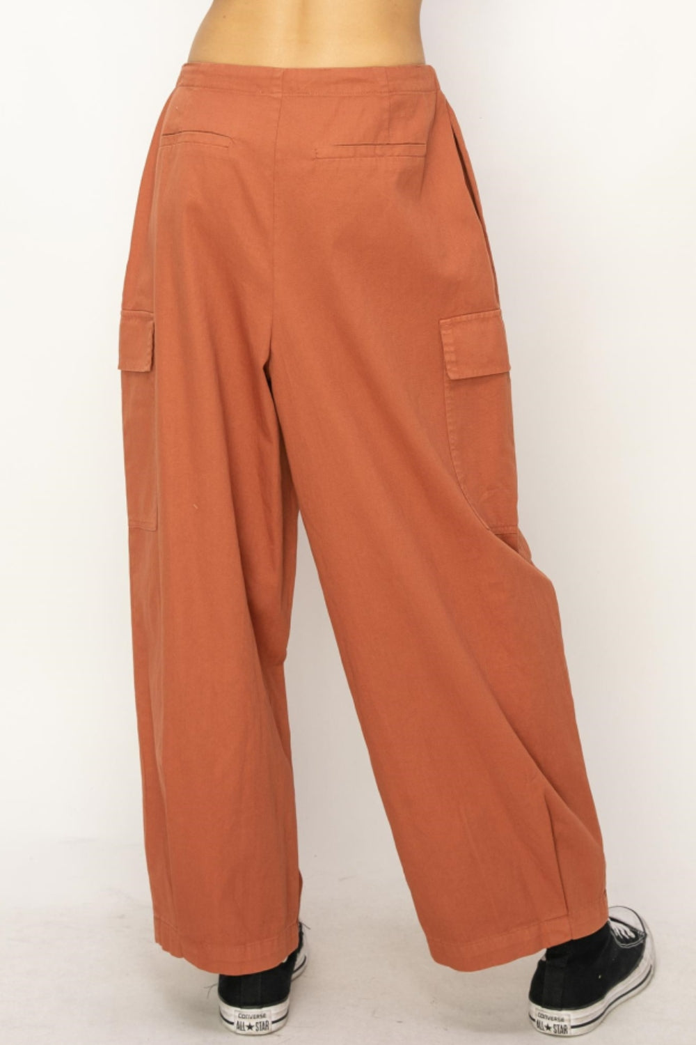 Drawstring wide leg cargo pants with utility pockets and relaxed fit in terracotta color.