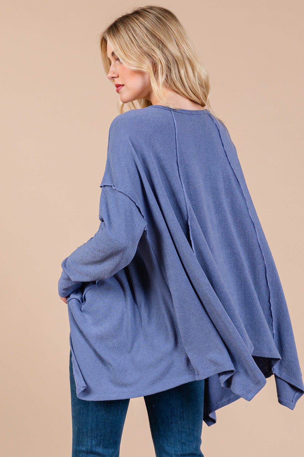 Oversized asymmetrical long sleeve top with hi-low hem and exposed seams.