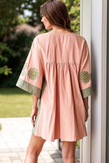 Printed V-neck three-quarter sleeve mini dress in peach with floral pattern.