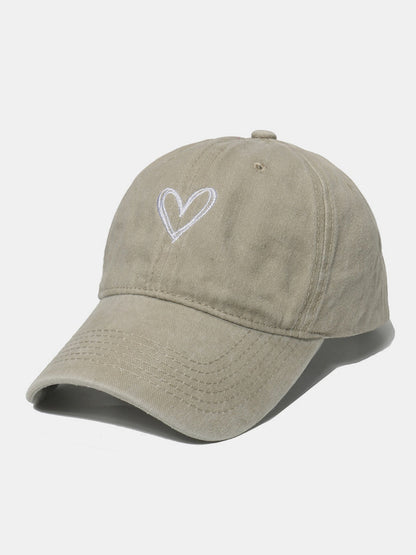 Pink embroidered heart baseball cap made of washed cotton with adjustable fit.