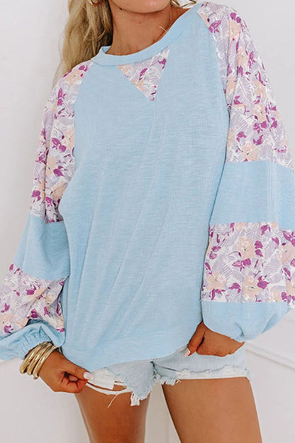 Women's printed round neck balloon sleeve blouse in light blue and floral design.