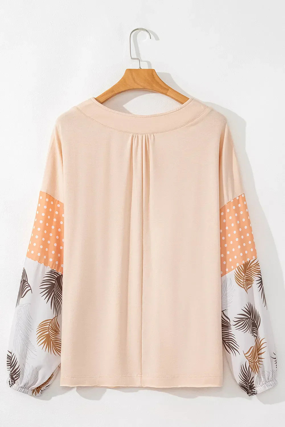 Printed V-Neck Long Sleeve Blouse with patterned sleeves on hanger.