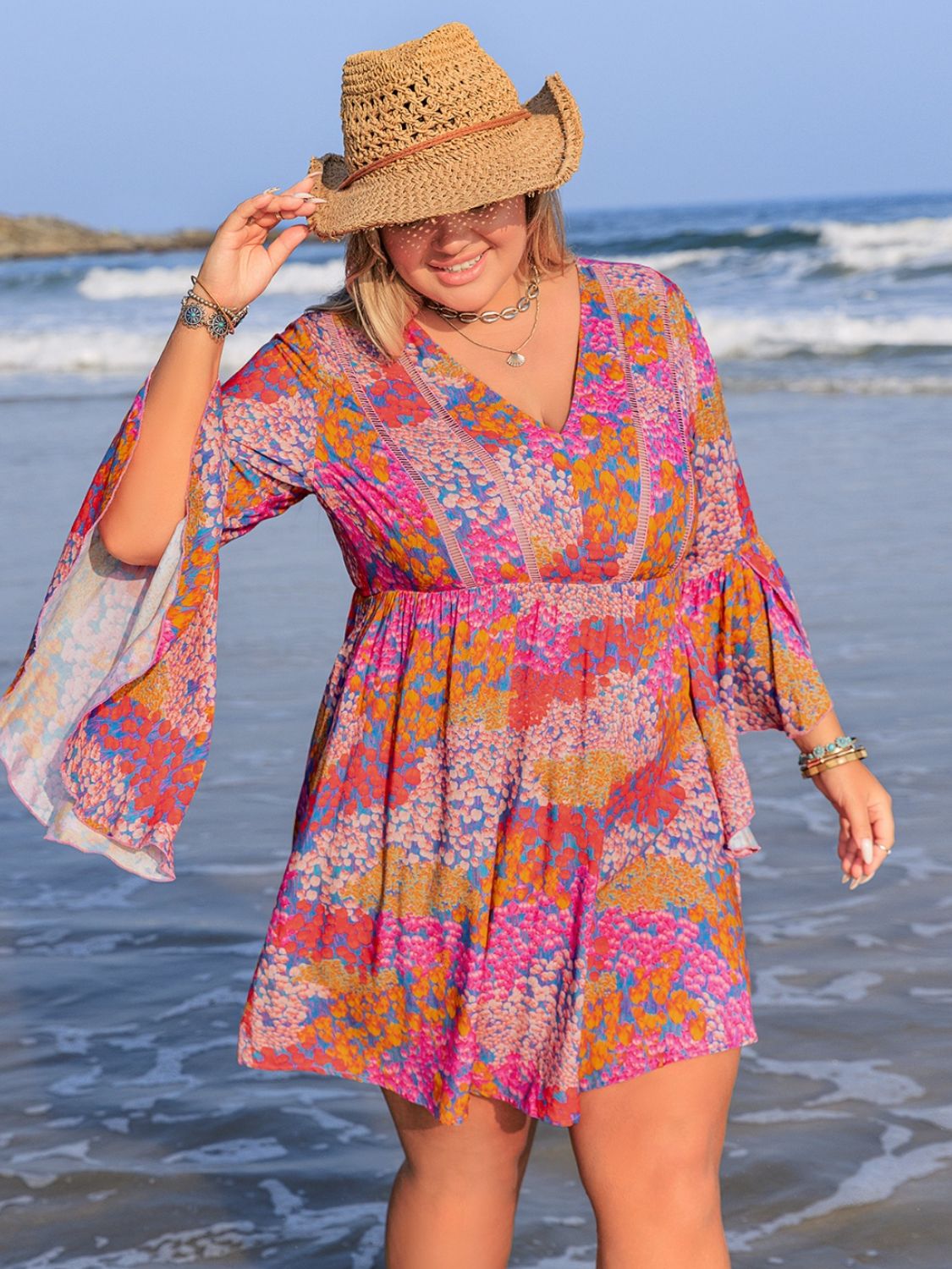 Plus size ruched printed long sleeve dress by the ocean.