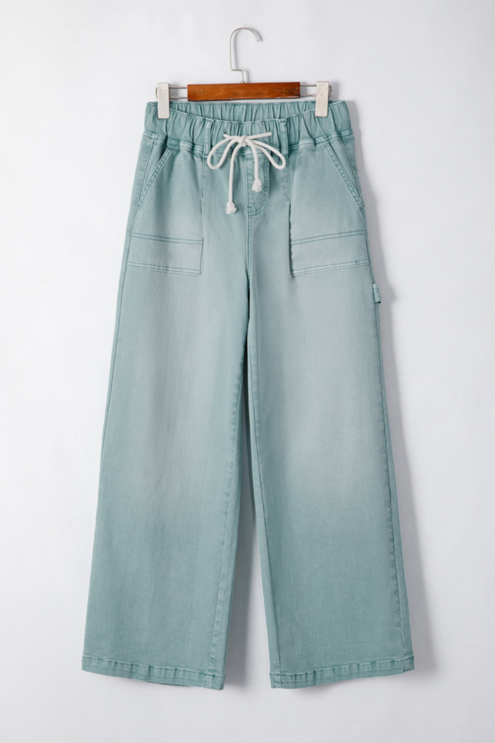 Smoke green mineral wash jeans with drawstring, high waist, and wide leg design.