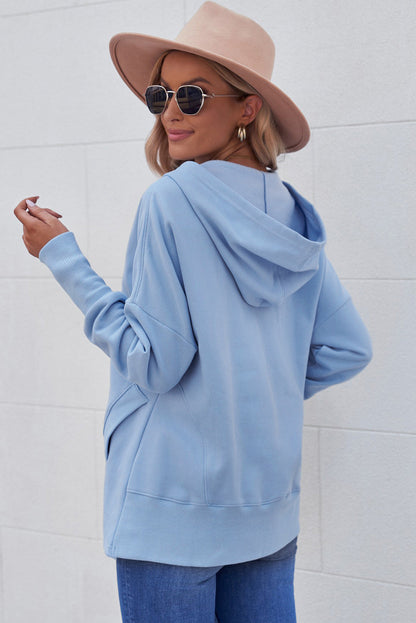 Quarter-Snap Dropped Shoulder Hoodie in light blue with pockets and button detail.