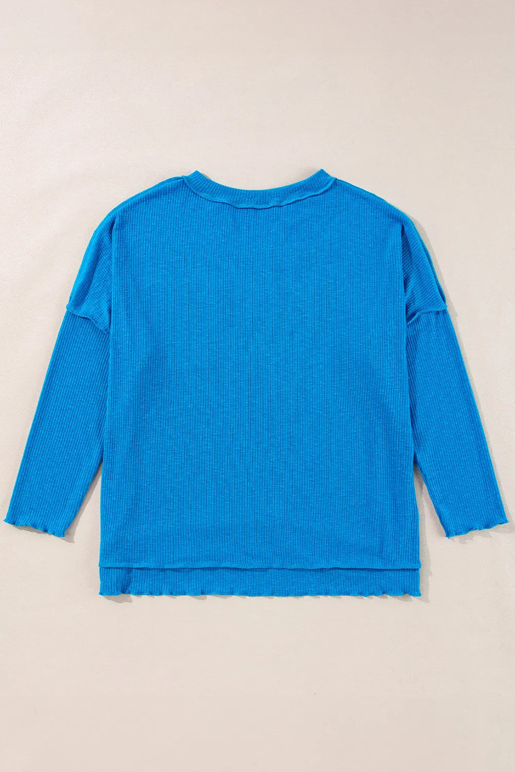 Blue exposed seam notched long sleeve blouse with pocket detailing.