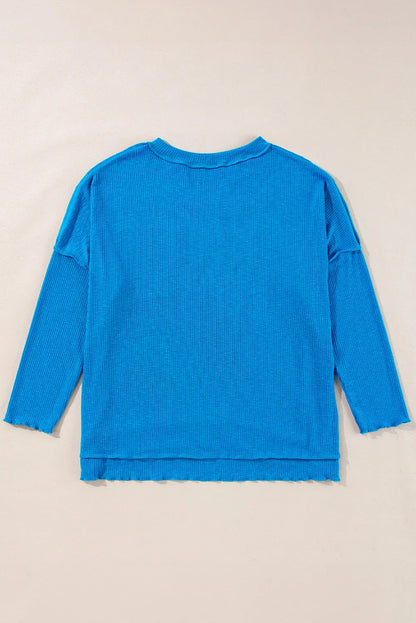 Blue exposed seam notched long sleeve blouse with pocket detailing.