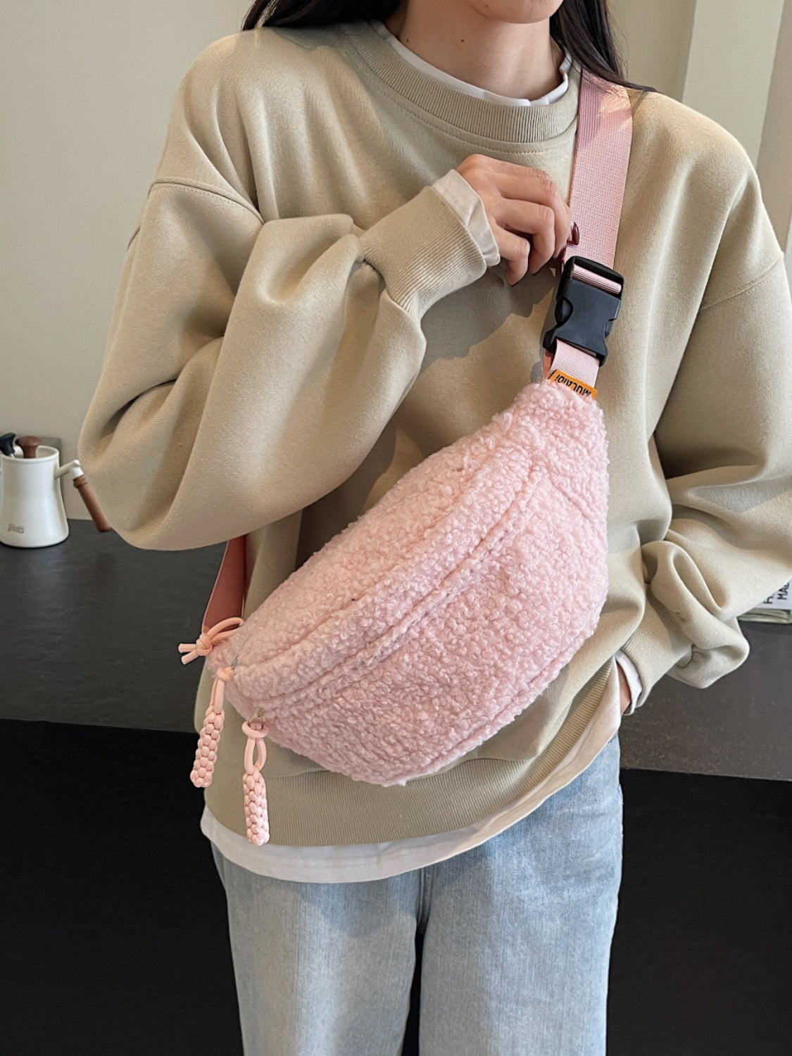 Medium polyester Sherpa crossbody bag with adjustable strap.