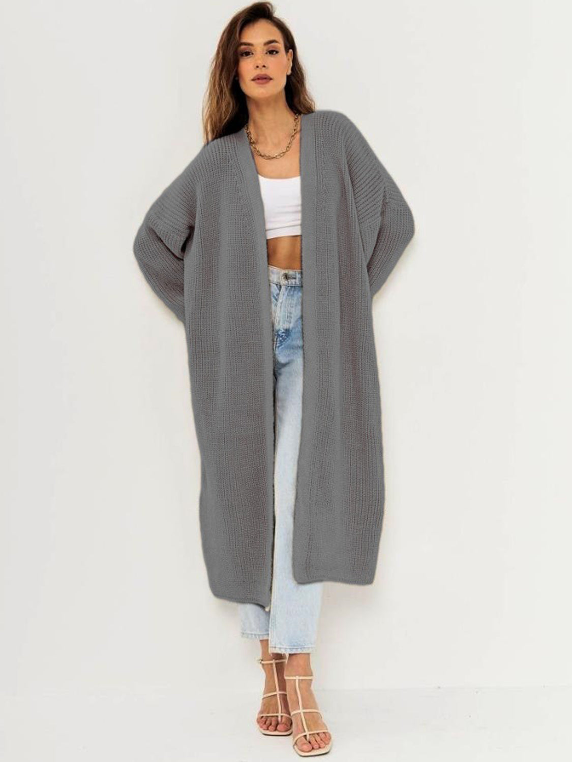 Open front long sleeve longline cardigan in gray, worn by a woman over a white top and jeans.